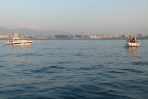 Dos embarcaciones durante la competición y al fondo Algeciras