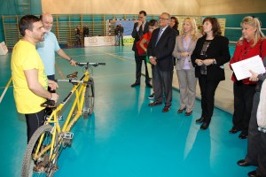Imagen donde están explicando el uso de una bicicleta doble para personas con discapacidad visual a los asistentes